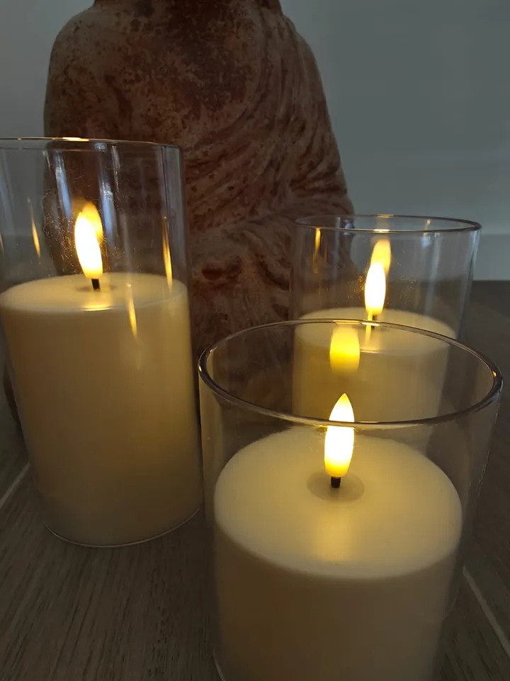 Bougies allumées dans des photophores en verre, à la lueur chaude