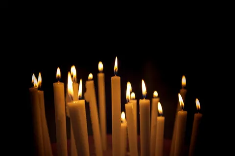 Rangées de bougies allumées dans la pénombre