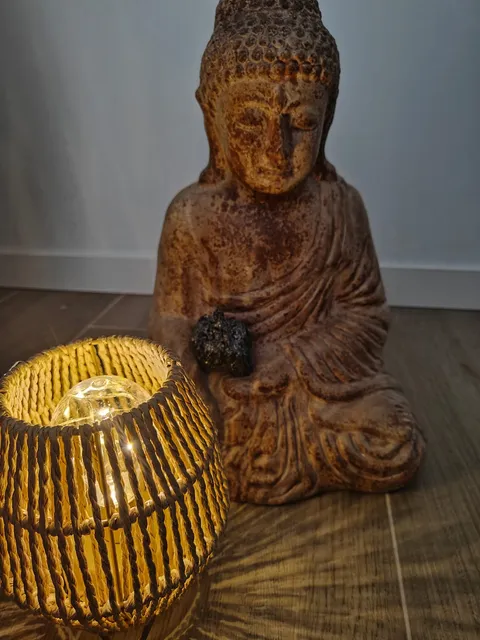 Statue de Bouddha, pierre et lanterne allumée dans la pénombre du cabinet